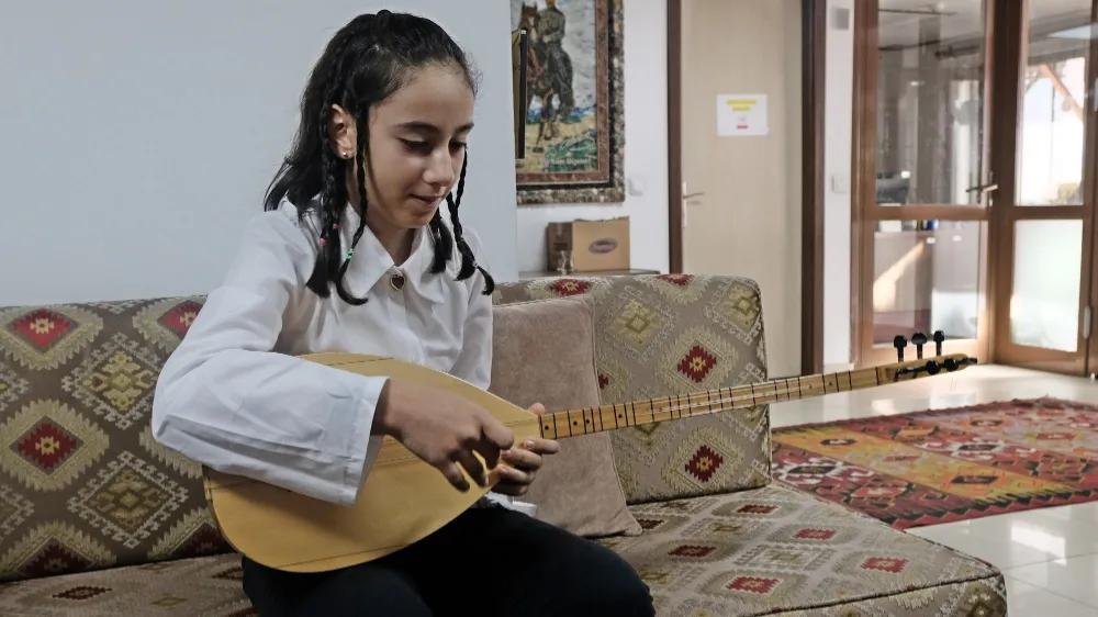 Elinde bağlamasıyla koronun en küçük üyesi